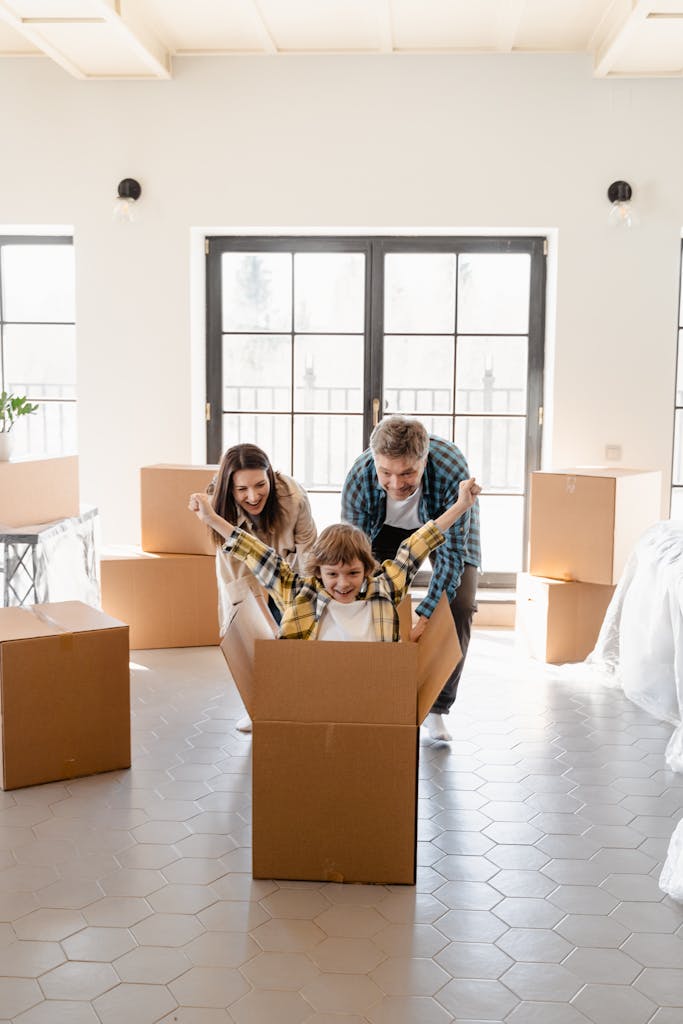 Happy family celebrating move into new home with unpacked boxes.